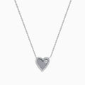 The 14K White Gold Diamond Heart Necklace showcases a heart-shaped pendant outlined with small diamonds and accented by a single larger diamond on one side, displayed against a plain white background.