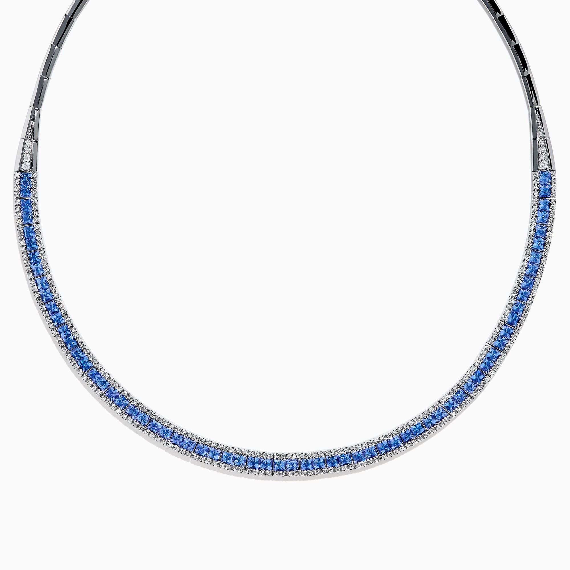 The 14K White Gold Tanzanite and Diamond Collar Necklace showcases a row of vivid blue tanzanites edged with sparkling diamonds on a sleek curved band, elegantly displayed against a white background.