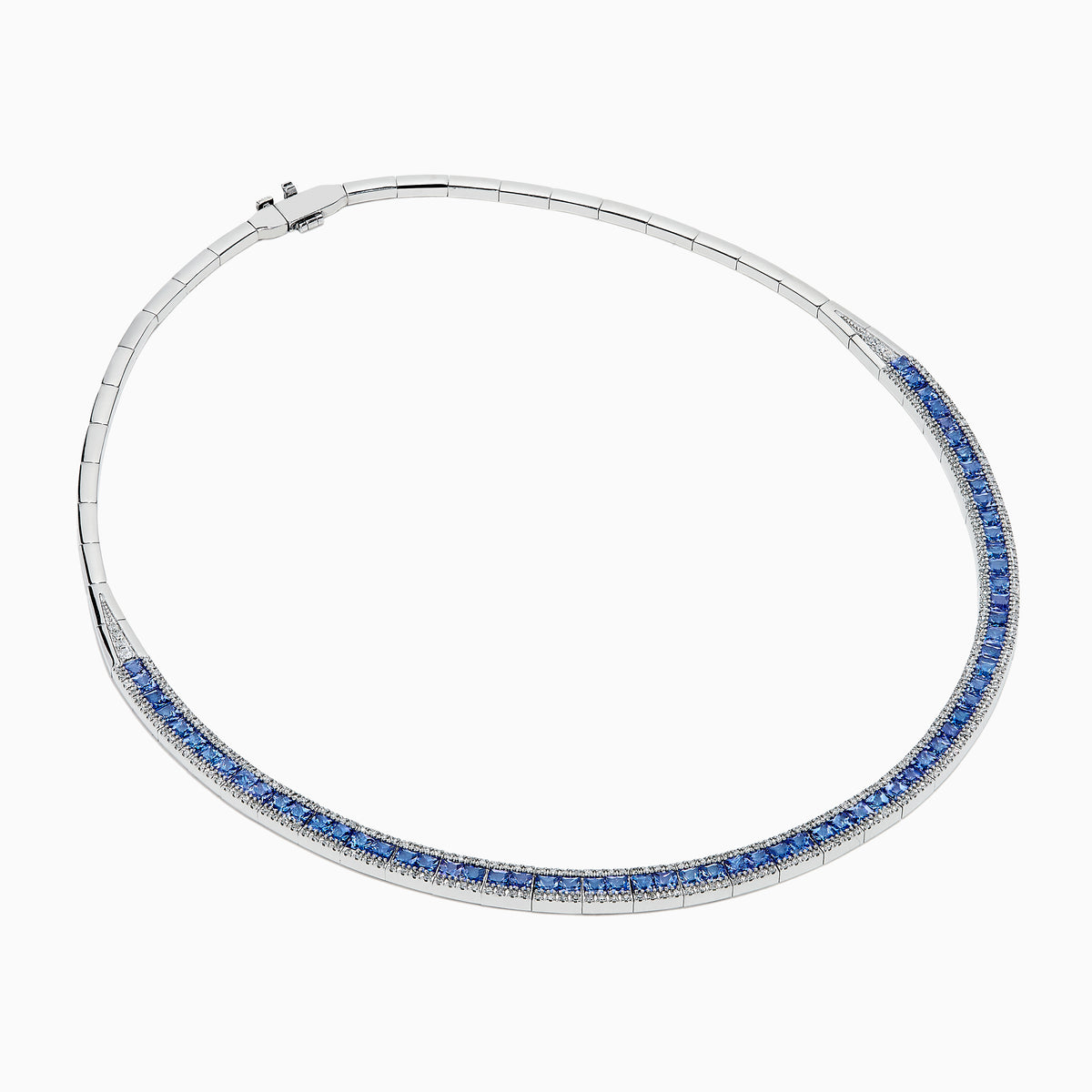 The 14K White Gold Tanzanite and Diamond Collar Necklace showcases a row of vivid blue tanzanites edged with sparkling diamonds on a sleek curved band, elegantly displayed against a white background.
