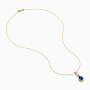 The Nahla 14K Yellow Gold Tanzanite Pendant features a teardrop blue tanzanite surrounded by diamonds and a diamond-accented bail, gleaming at the center of this elegant necklace.