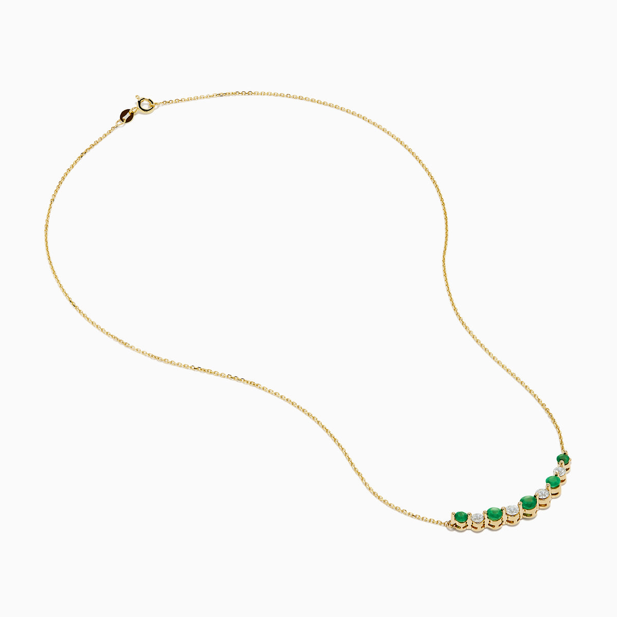 The 14K Yellow Gold Emerald and Diamond Necklace showcases alternating round emerald and diamond stones set in a gentle curve at the center.