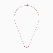 The 14K Rose Gold Pink Sapphire and Diamond Necklace features seven heart-shaped pink sapphires and six small round diamonds set in an alternating pattern along a delicate rose gold chain.