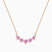 The 14K Rose Gold Pink Sapphire and Diamond Necklace features seven heart-shaped pink sapphires and six small round diamonds set in an alternating pattern along a delicate rose gold chain.