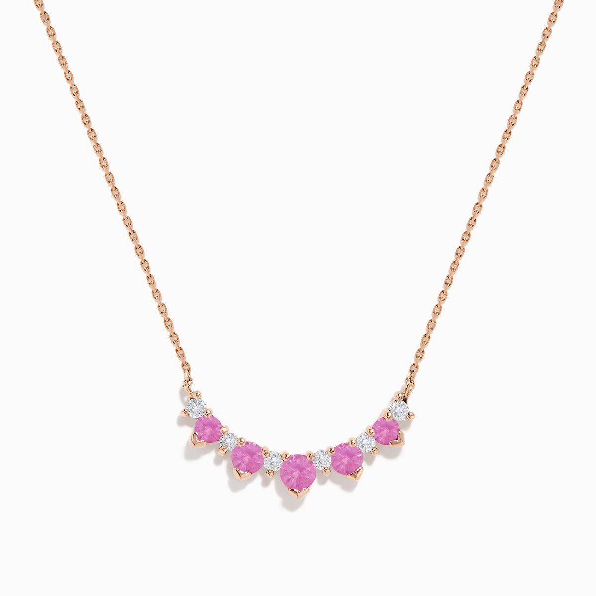 The 14K Rose Gold Pink Sapphire and Diamond Necklace features seven heart-shaped pink sapphires and six small round diamonds set in an alternating pattern along a delicate rose gold chain.