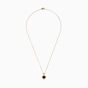 The 14 Karat Yellow Gold Rhodolite Garnet and Diamond Heart Pendant features a deep red garnet heart encircled by sparkling diamonds, elegantly suspended from a gold chain on a white background.