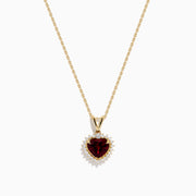The 14 Karat Yellow Gold Rhodolite Garnet and Diamond Heart Pendant features a deep red garnet heart encircled by sparkling diamonds, elegantly suspended from a gold chain on a white background.