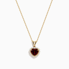 The 14 Karat Yellow Gold Rhodolite Garnet and Diamond Heart Pendant features a deep red garnet heart encircled by sparkling diamonds, elegantly suspended from a gold chain on a white background.
