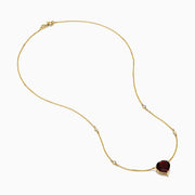 The Bordeaux 14K Yellow Gold Garnet and Diamond Heart Necklace features a heart-shaped red garnet pendant accented by two round diamonds on a delicate gold chain.