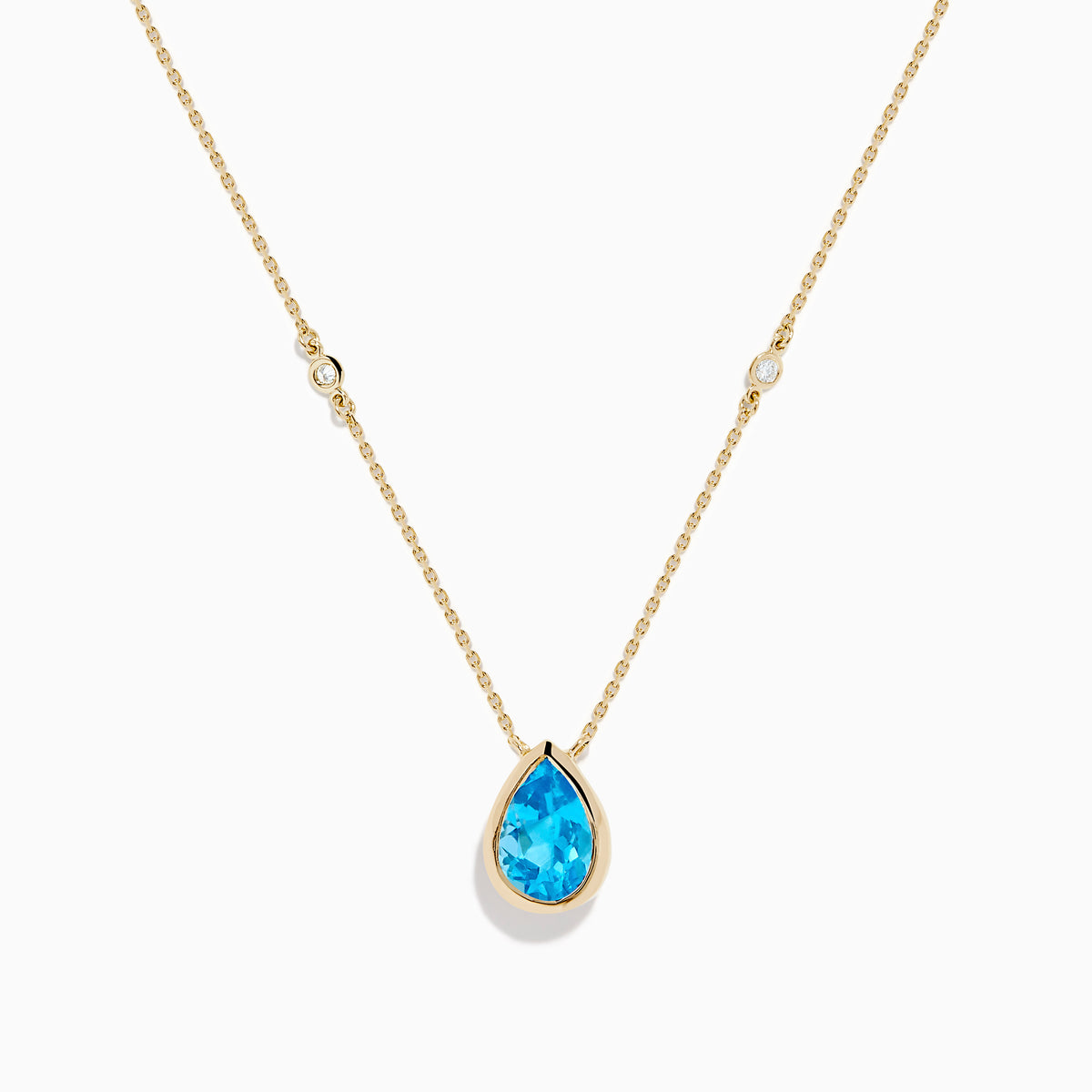 The Ocean Bleu 14K Yellow Gold Blue Topaz and Diamond Necklace features a teardrop blue topaz pendant with two round diamonds set on a delicate chain, shown on a white background.