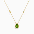 The 14K Yellow Gold Peridot and Diamond Necklace features a delicate gold chain with a teardrop-shaped green peridot pendant and two small round diamonds set along the chain.