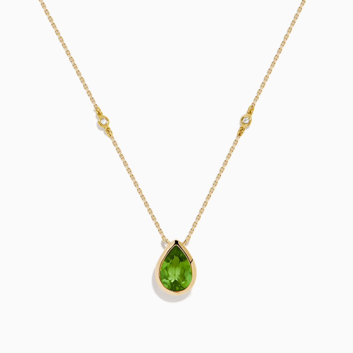 The 14K Yellow Gold Peridot and Diamond Necklace features a delicate gold chain with a teardrop-shaped green peridot pendant and two small round diamonds set along the chain.