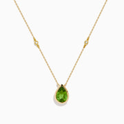 The 14K Yellow Gold Peridot and Diamond Necklace features a delicate gold chain with a teardrop-shaped green peridot pendant and two small round diamonds set along the chain.
