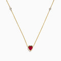 The Ruby Royale 14K Yellow Gold Ruby and Diamond Heart Necklace features a red heart-shaped pendant with a round diamond on each side, displayed on a white background.
