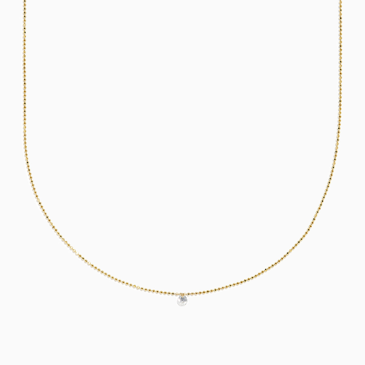 The 14K Yellow Gold Floating Diamond Solitaire Beaded Chain Necklace showcases a small round diamond pendant at the center, set against a plain white background.