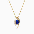 The Nahla Siri 14K Yellow Gold Floating Tanzanite and Diamond Pendant features a vibrant tanzanite gemstone and sparkling diamonds set in a curved gold pendant, displayed on a classic gold chain against a white background.