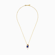 The Nahla Siri 14K Yellow Gold Floating Tanzanite and Diamond Pendant features a vibrant tanzanite gemstone and sparkling diamonds set in a curved gold pendant, displayed on a classic gold chain against a white background.