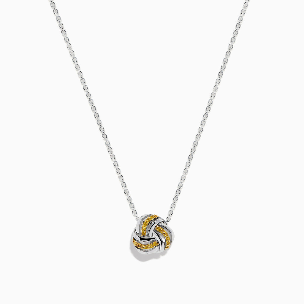 A 14K white gold love knot pendant with yellow diamonds hangs on a delicate chain, showcased against a white background.
