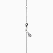 A 14K white gold love knot pendant with yellow diamonds hangs on a delicate chain, showcased against a white background.