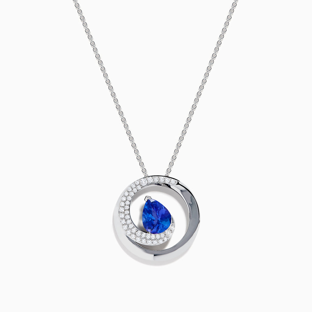 The Nahla 14K White Gold Tanzanite Swirl Pendant features a white gold necklace with a swirl design, sparkling clear gemstones, and a central teardrop-shaped blue tanzanite.