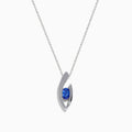 Elegant 14K white gold pendant featuring a curved design and centered with a round blue tanzanite, accented by diamonds, shown on a white background.