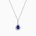 A 14K white gold pear tanzanite and diamond halo pendant with a diamond-studded bail, displayed on a white background.
