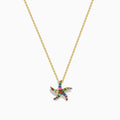 The Seaside 14K Yellow Gold Multi Sapphire Starfish Pendant features a delicate gold chain with a sapphire starfish-shaped pendant adorned with multicolored gemstones, shown elegantly against a white background.