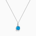 This 14K white gold blue topaz and diamond pendant features a round, vibrant blue topaz and dazzling diamonds set on the bail.