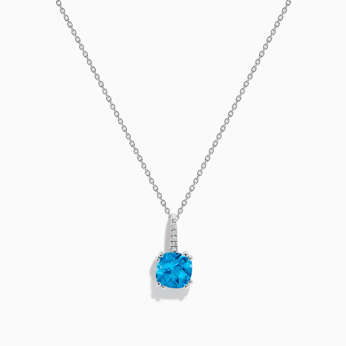 This 14K white gold blue topaz and diamond pendant features a round, vibrant blue topaz and dazzling diamonds set on the bail.