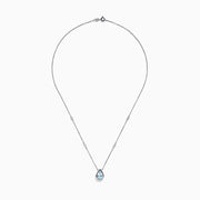 The Aquarius 14K Yellow Gold Aquamarine Necklace features a teardrop-shaped light blue gemstone pendant and small round crystal accents along the chain—an elegant gift, beautifully displayed on a white background.
