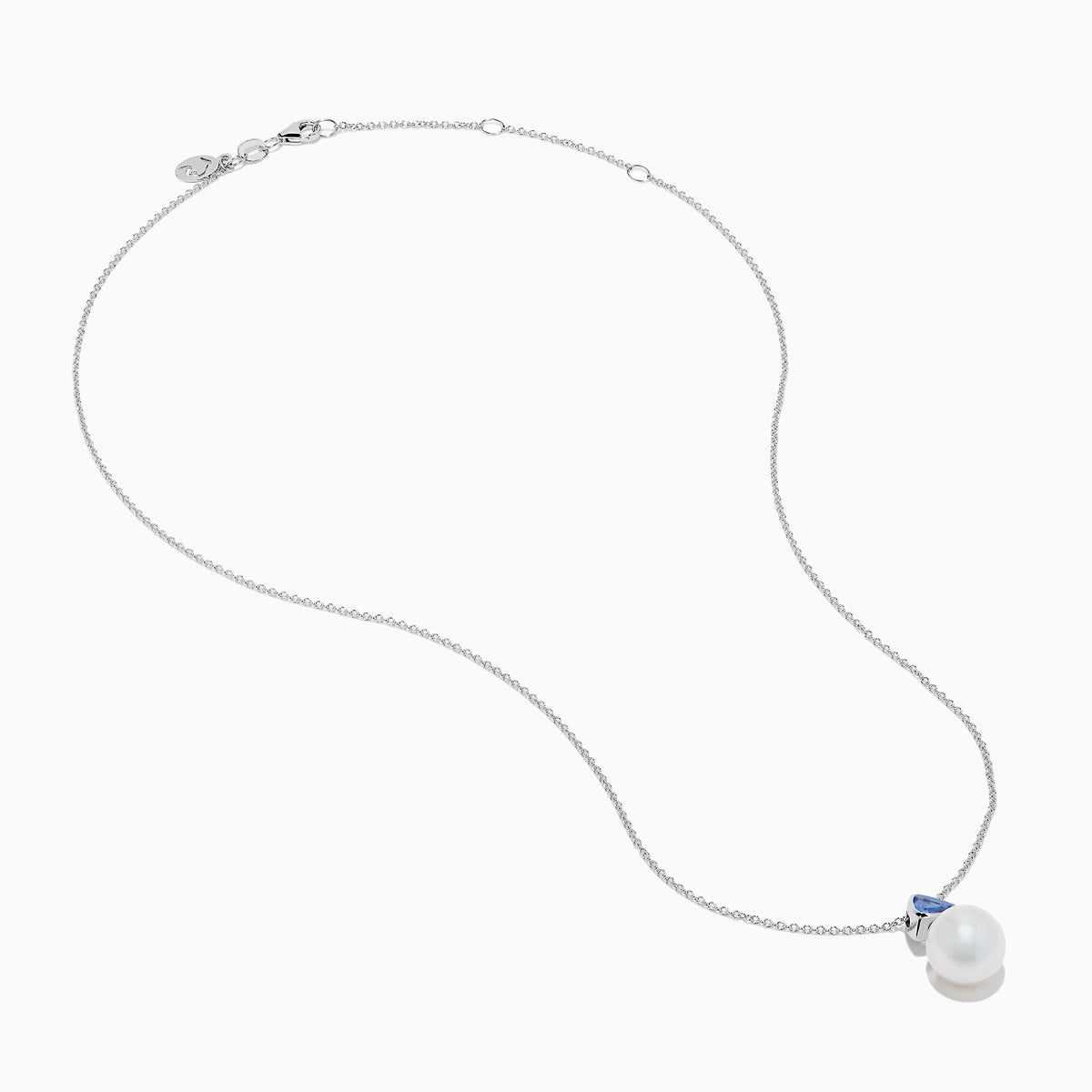 The Nahla 14K White Gold Fresh Water Pearl and Tanzanite Pendant features a round pearl accented with a small, triangular blue tanzanite, all set in white gold and shown against a plain white background.