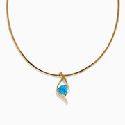 The Ocean Bleu 14K Yellow Gold Blue Topaz and Diamond Pendant features a twisting diamond design, centered with a vivid blue topaz and accented by small diamonds along one side, displayed on a plain white background.