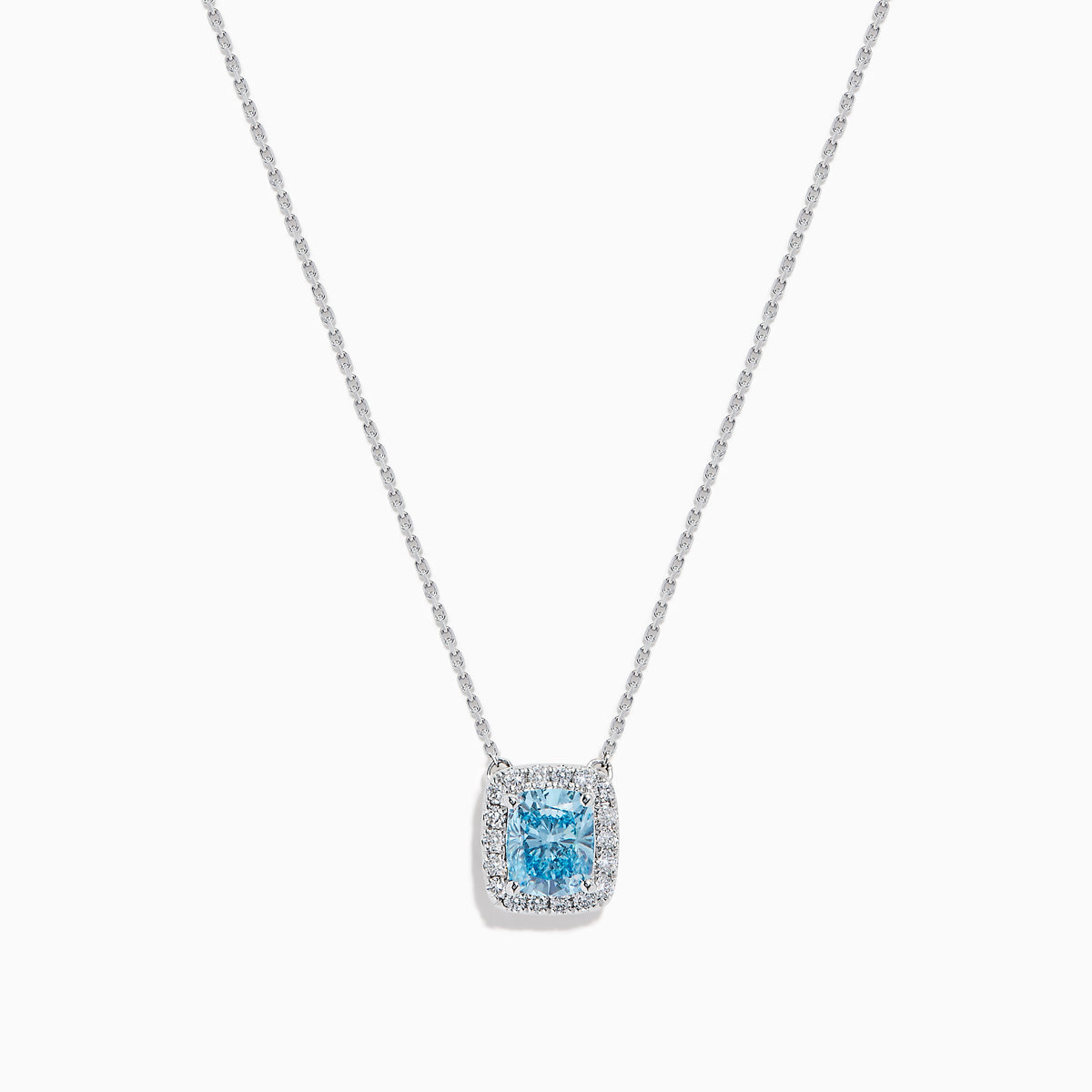 The Lab Grown Blue and White Diamond Halo Necklace in 14K White Gold features a square blue and white diamond pendant surrounded by clear stones, elegantly displayed against a white background.