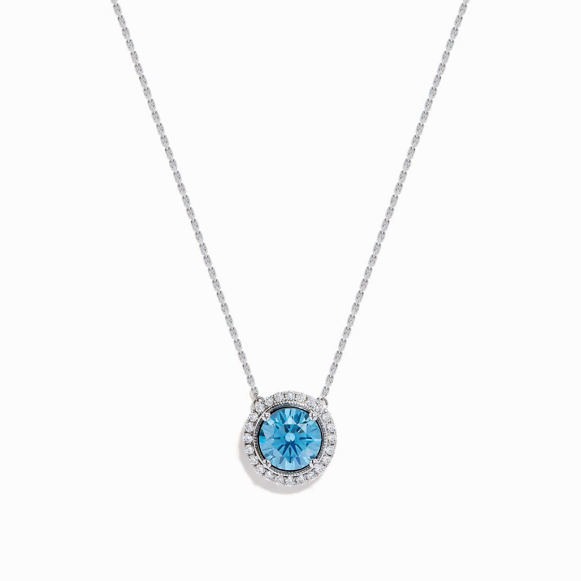 The Lab Grown Blue and White Diamond Halo Necklace in 14K White Gold features a round blue gemstone pendant encircled by sparkling lab grown diamonds, shown against a white background.