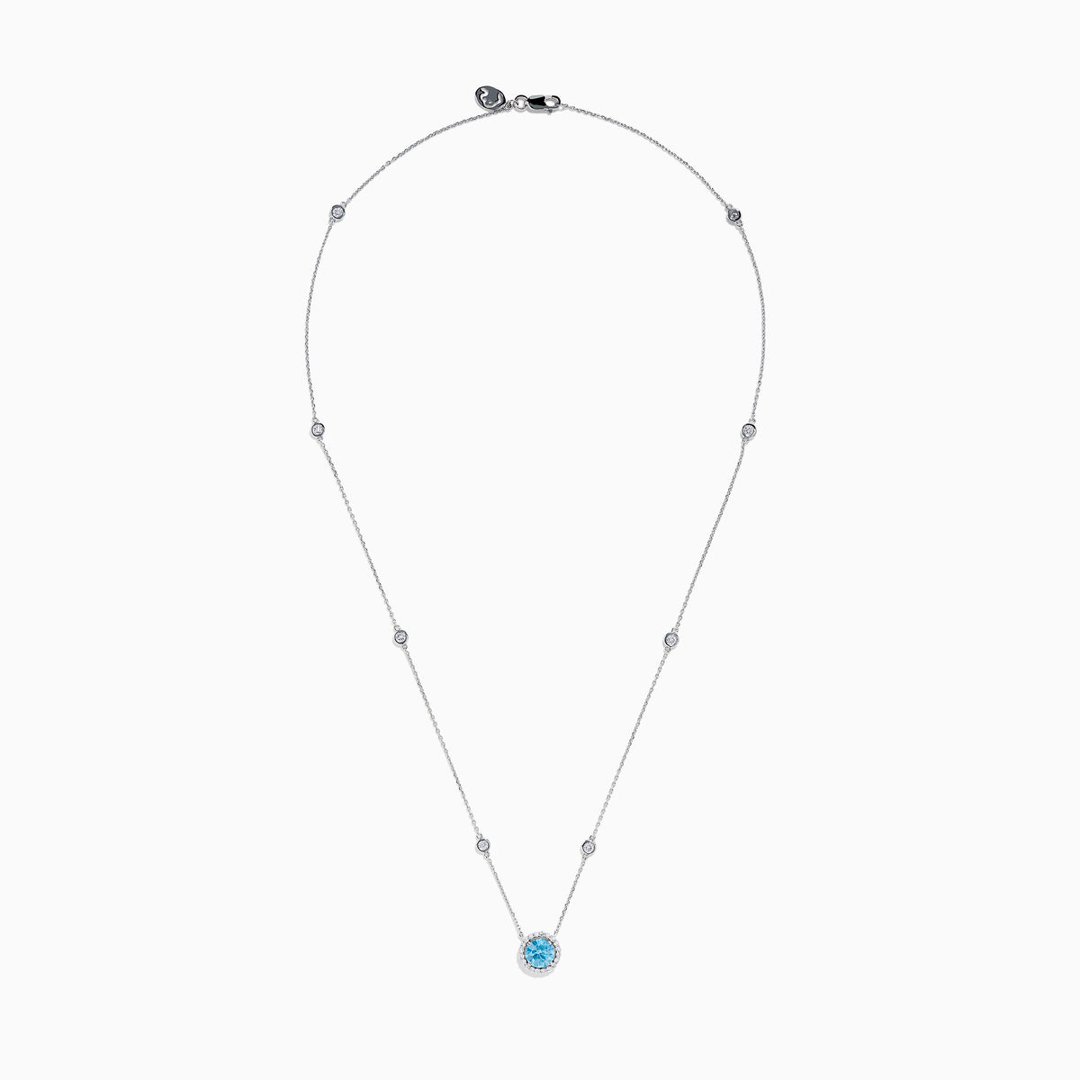The Lab Grown Blue and White Diamond Halo Necklace in 14K White Gold features a round blue gemstone pendant surrounded by lab grown diamonds, plus two small clear stones set along the chain.