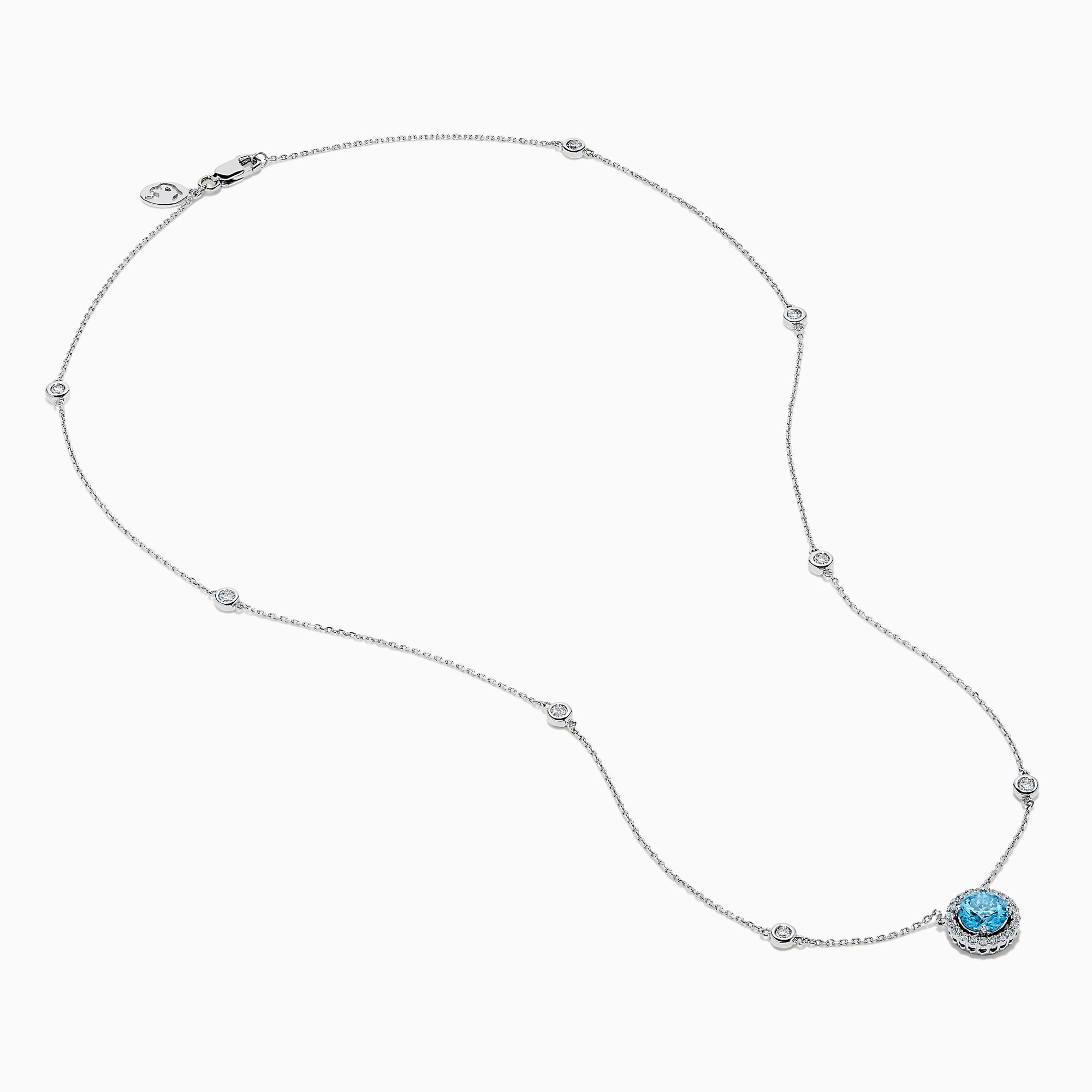 The Lab Grown Blue and White Diamond Halo Necklace in 14K White Gold features a round blue gemstone pendant surrounded by lab grown diamonds, plus two small clear stones set along the chain.