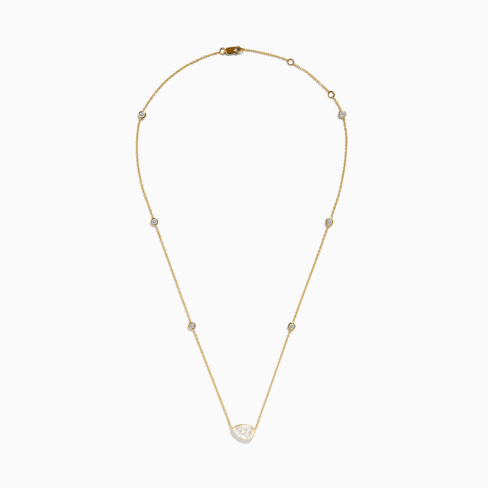 The Lab Grown Diamond Pear Station Necklace in 14K Yellow Gold features a large pear-shaped lab diamond pendant and two small round lab diamonds set along a delicate gold chain.