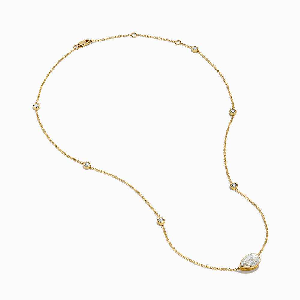 The Lab Grown Diamond Pear Station Necklace in 14K Yellow Gold features a large pear-shaped lab diamond pendant and two small round lab diamonds set along a delicate gold chain.