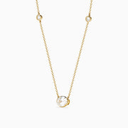 The Lab Grown Diamond Oval Station Necklace in 14K Yellow Gold features a central oval-shaped diamond pendant and two small round diamonds set along each side of the chain, creating an elegant, delicate look.