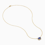 The Nahla 14K White Gold Tanzanite and Diamond Halo Necklace features a central blue oval tanzanite gemstone encircled by diamonds, shown on a white background.