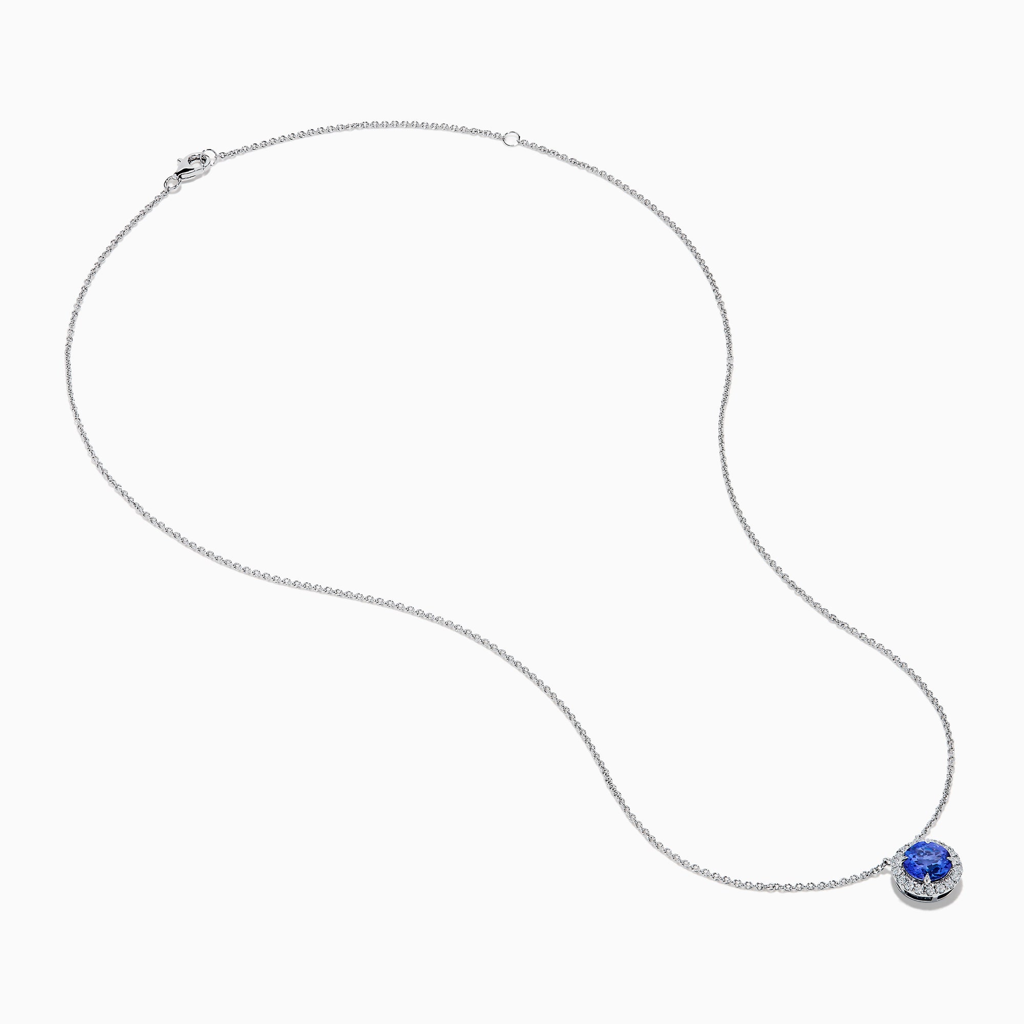 The Nahla 14K White Gold Tanzanite and Diamond Halo Necklace features a round blue tanzanite pendant encircled by sparkling diamonds on a delicate silver chain, creating an elegant look against a plain white background.