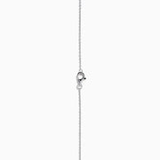 The Nahla 14K White Gold Tanzanite and Diamond Halo Necklace features a round blue tanzanite pendant encircled by sparkling diamonds on a delicate silver chain, creating an elegant look against a plain white background.