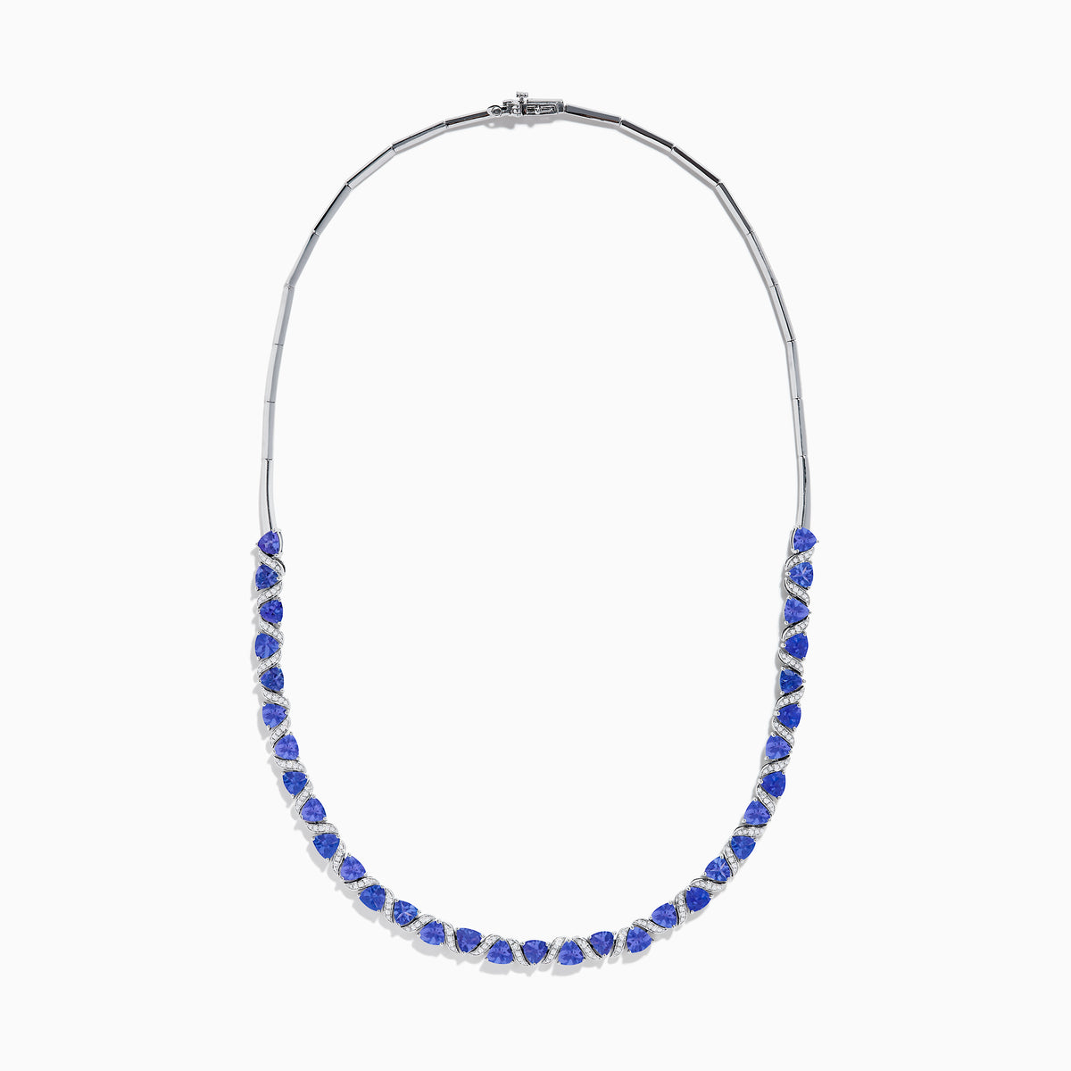 The Nahla Siri 14K White Gold Trillion Cut Tanzanite and Diamond Necklace features alternating deep blue tanzanites and small diamonds set along a 14K white gold chain, elegantly displayed against a white background.