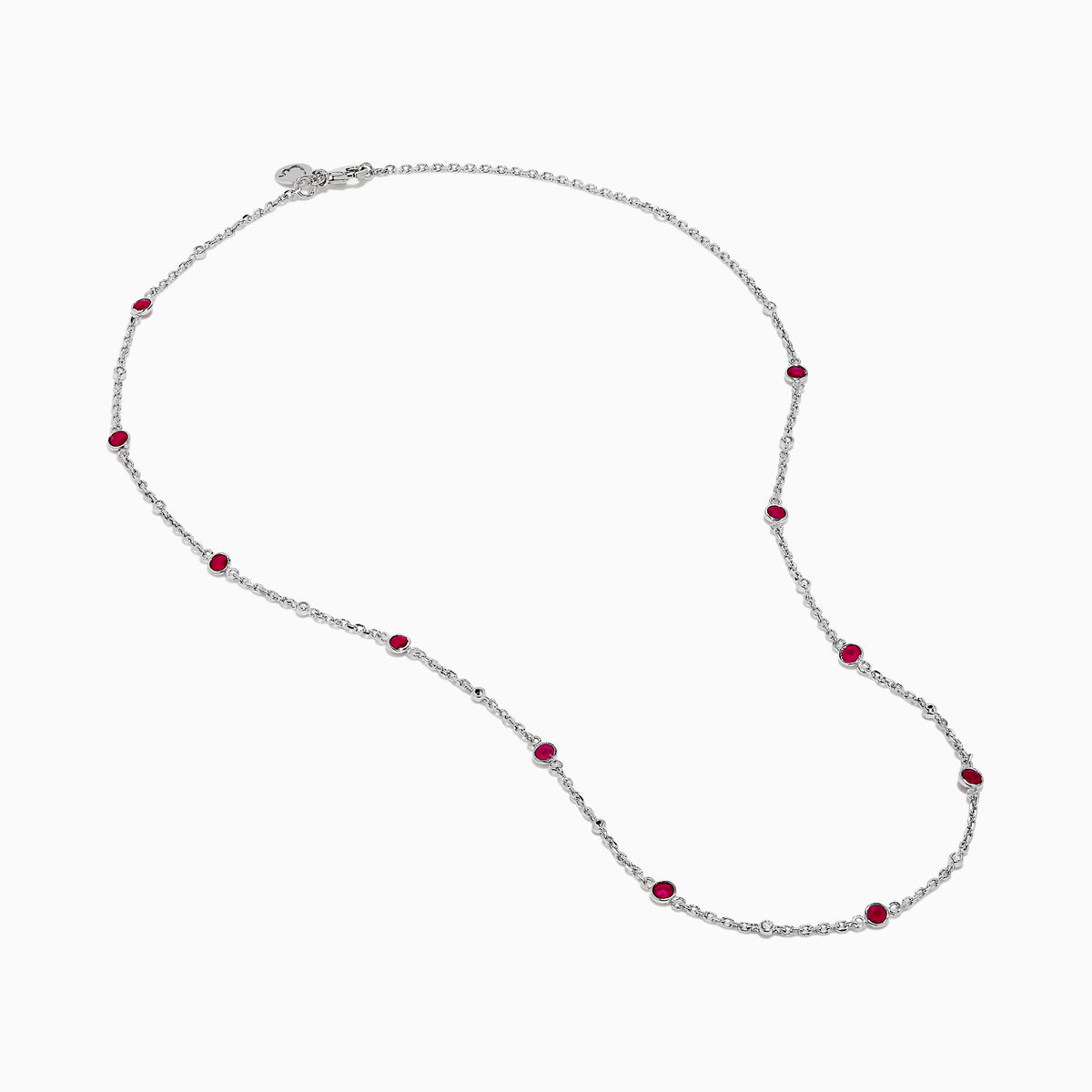 The Ruby Royale 925 Sterling Silver Necklace showcases alternating bezel-set rubies and diamonds along a delicate chain, elegantly displayed against a plain white background.