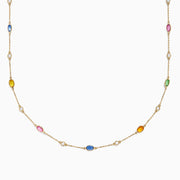 The 14K Yellow Gold Multi Sapphire and Diamond Station Necklace showcases blue, pink, yellow, green, and orange oval sapphires with a diamond station, all delicately spaced along the chain.