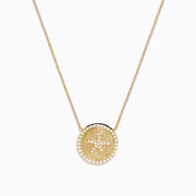 The Seaside 14K Yellow Gold Diamond Starfish Necklace showcases a round, textured pendant with a central starfish design, elegantly outlined and adorned with sparkling diamonds along the edge.