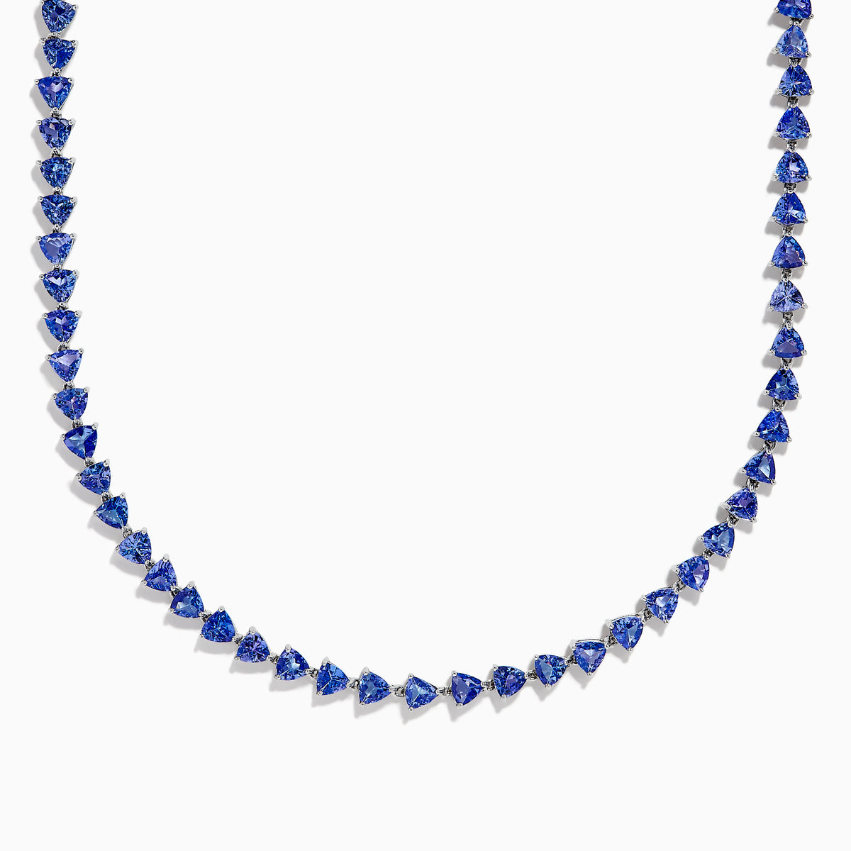 The Nahla Siri Sterling Silver Tanzanite Trillion Cut Tennis Necklace features evenly spaced, triangular tanzanite stones set in 925 silver, creating a continuous, symmetrical design against a plain white background.