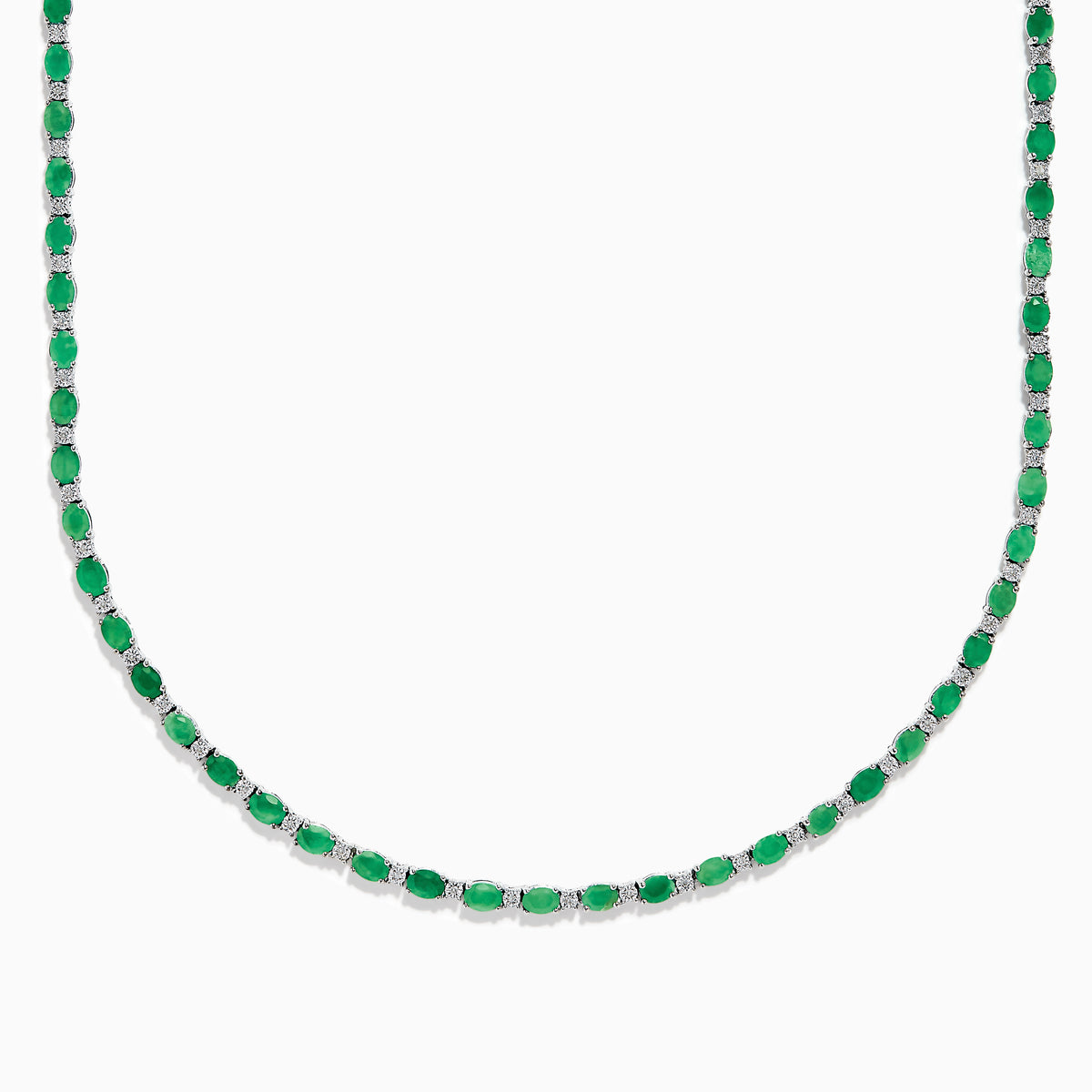 The 925 Sterling Silver Emerald and Diamond Tennis Necklace showcases a sleek row of oval green emeralds and sparkling diamonds set in sterling silver, beautifully arranged against a crisp white background.
