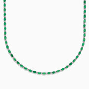 The 925 Sterling Silver Emerald and Diamond Tennis Necklace showcases a sleek row of oval green emeralds and sparkling diamonds set in sterling silver, beautifully arranged against a crisp white background.