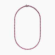The 925 Sterling Silver Ruby and Diamond Tennis Necklace showcases a continuous row of oval red gemstones in silver prong settings, elegantly displayed against a white background.