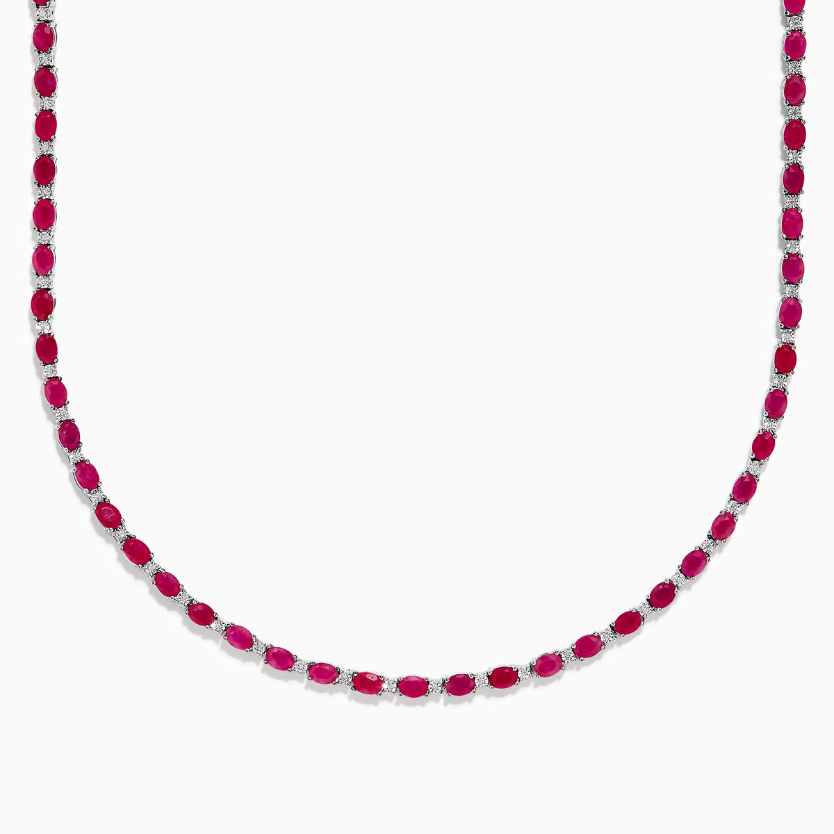 The 925 Sterling Silver Ruby and Diamond Tennis Necklace showcases a continuous row of oval red gemstones in silver prong settings, elegantly displayed against a white background.